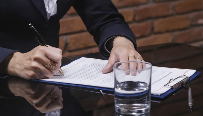 Close-up of Businesswoman signing job contract in office